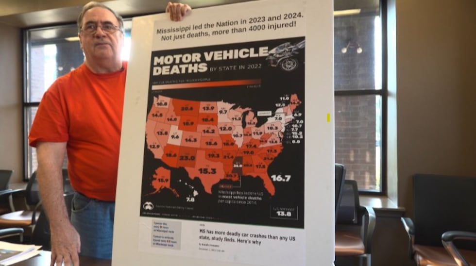 Richard Bouchard holds up a map of the U.S. that depicts fatal car accidents from state to state.